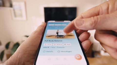 Frau hat ihr Training auf der bellicon+ Plattform ausgewählt und streamt das Workout auf den Fernseher.