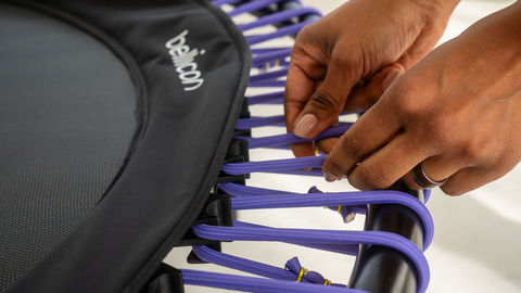 A woman showing the purple bungees on the bellicon.