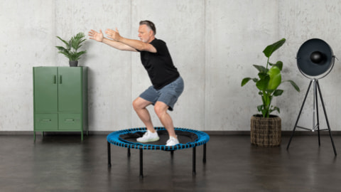 Man doing squat on bellicon trampoline