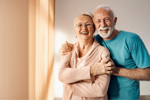 Älteres Ehepaar umarmen sich und sind glücklich.
